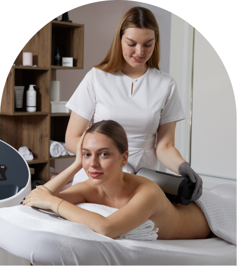 A woman receiving a treatment from a therapist with a device in a spa setting.